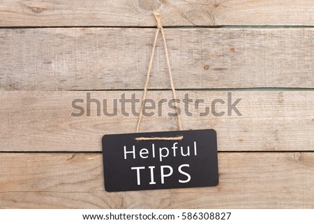 Blackboards with inscription "Helpful TIPS" on wooden background Royalty-Free Stock Photo #586308827