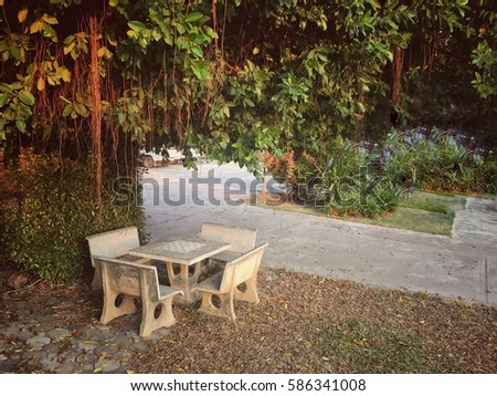 Public places for relax,the chair and table behind the tree