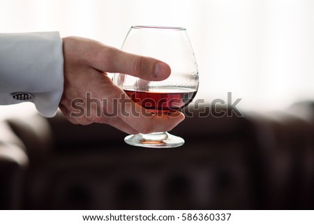 Hand with a glass of cognac