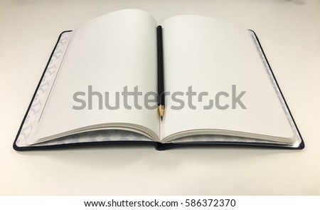 A blank book with a black pencil