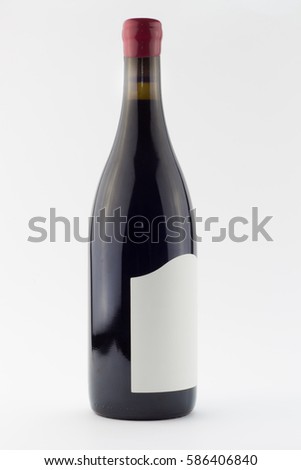 Red wine bottle isolated on white - full bottle of red wine standing upright with red wax seal over cork