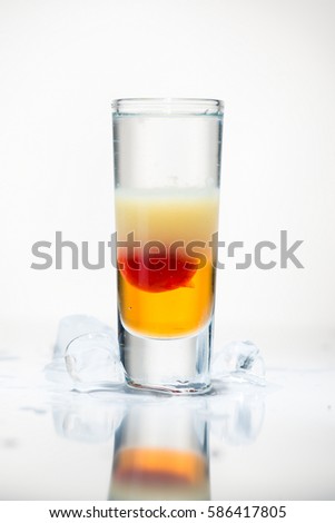 alcohol cocktail shot on a light background with reflection