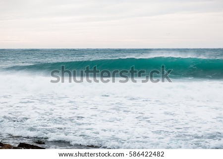 Blue wave in ocean and clouds sky