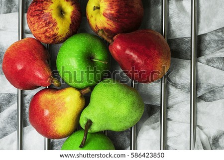 Wholesome, delicious, mouth-watering apples and pears. Laid out on a light surface. The red and green. Top view, closeup. Healthy eating, lifestyle