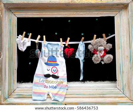 children's clothes on the rope on the background of a wooden picture frame
