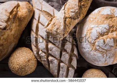 Several types of fresh bread lying on an old wooden table