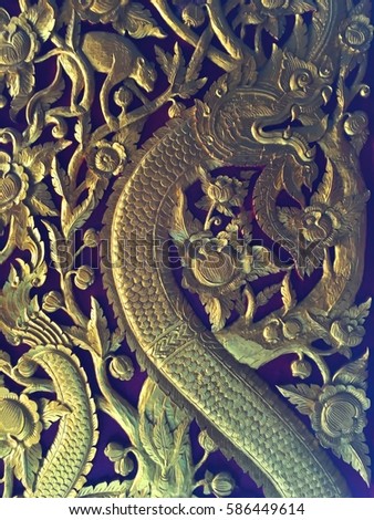 high Relief sculpture of gold serpent in the forest.