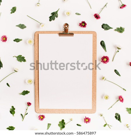 Clipboard mock up and wildflower pattern. Flat lay, top view. Flower background