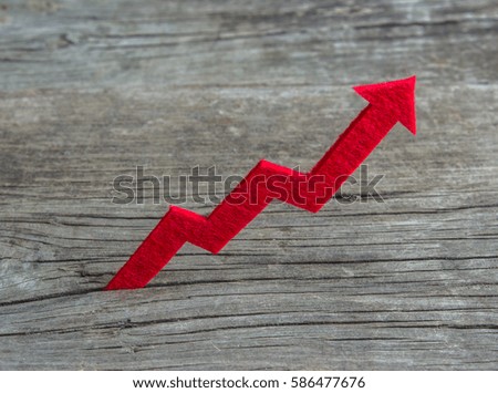 Red graph is growing up on a wooden background