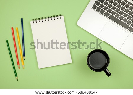 Modern office desk table with laptop, blank notebook page for input the text in the middle and other supplies. Top view, flat lay