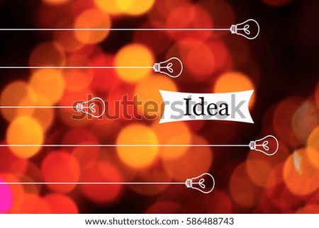 Light bulb hanging from the top with inscription IDEA on a colorful background bokeh lights led. Information concept, creative, technology and innovation. Image has Shallow DOF or grain or blurry.