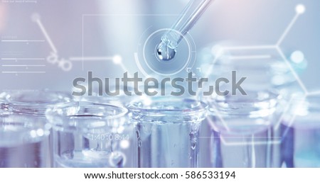 In a futuristic laboratory, a scientist with a pipette analyzes a colored liquid to extract the DNA and molecules in the test tubes.Concept:research,biochemistry,immersive technology,augmented reality Royalty-Free Stock Photo #586533194