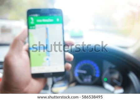 Picture blurred  for background abstract and can be illustration to article of Hand using a smartphone while driving a car
