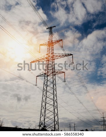Silhouette of high voltage electrical pole. Sunset sky background