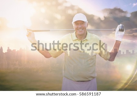 Picture of city by sunrise against portrait of smiling mature golfer carrying golf club