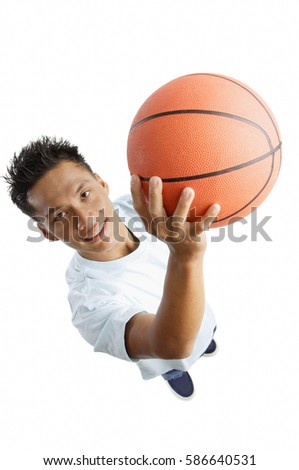 Young man holding basketball, looking up at camera