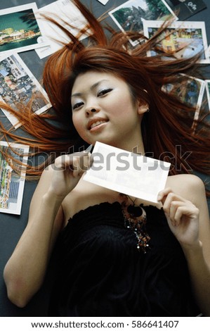 Woman lying on floor, holding postcard