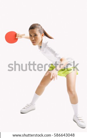 Young woman playing table tennis, studio shot