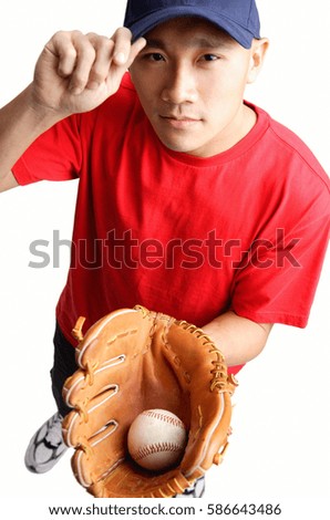 Young man holding baseball glove and ball, adjusting cap