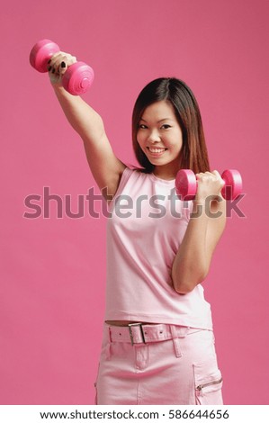 Woman dressed in pink, using dumbbells