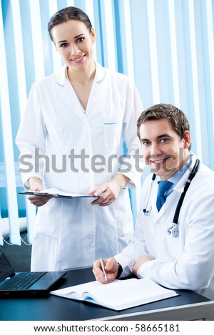 Two happy medical people working together at office