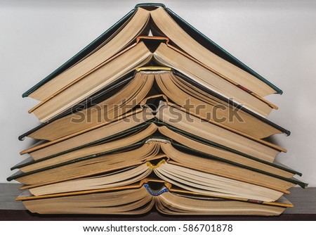 a stack of books standing on a shelf, assorted colors