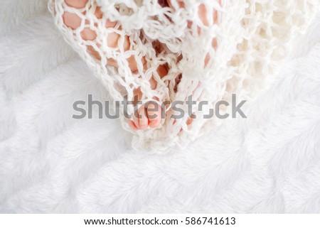 Close up picture of new born baby feet in knitted blanket