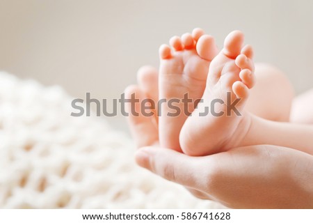 Baby feet in mother hands. Mom and her Child. Happy Family concept. Beautiful conceptual image of Maternity Royalty-Free Stock Photo #586741628