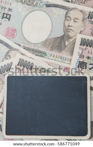 Concept image of Japan's Yen paper money with blank mini blackboard.