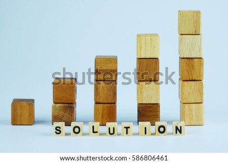 Square wood block of higher wooden block tower in form of graph shape, metaphor to business keep growing and rising or to complete. Selective focus and solution block text concept.