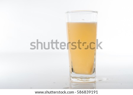 A dissolving tablet in an orange drinking water over white background
