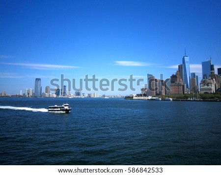 A ferry passing the upper bay of New York city with its skyline in the background