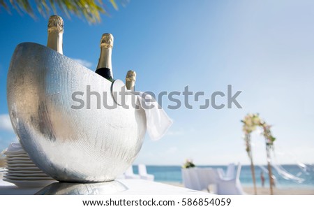 Beautiful close-up picture of icy champagne container on the beach. Chilled ice bucket with Bright background, shining sun and sea, in Mauritius tropical island