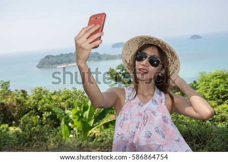 Beautiful Asian girl using smart phone at the viewpoint while her traveling.