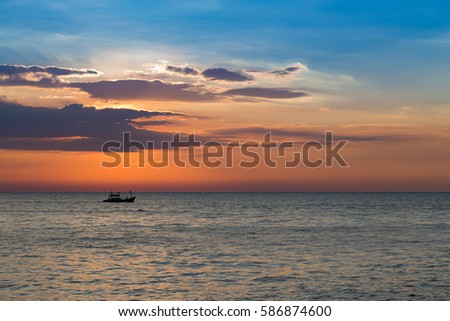 Beautiful sunset sky over seacoast skyline with small fishing boat in the ocean, natural landscape background
