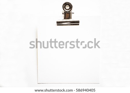 Hand holding clip on white canvas paper.
