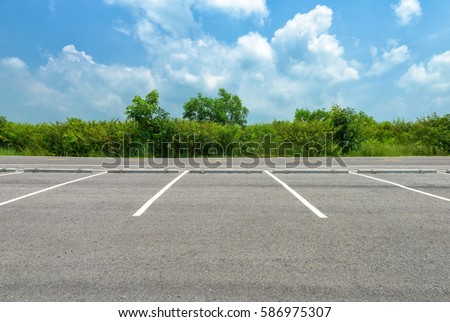 Empty parking lot on blue sky background Royalty-Free Stock Photo #586975307