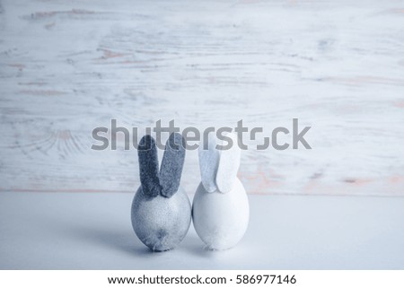 Cute creative eggs looks like bunny on white wooden background