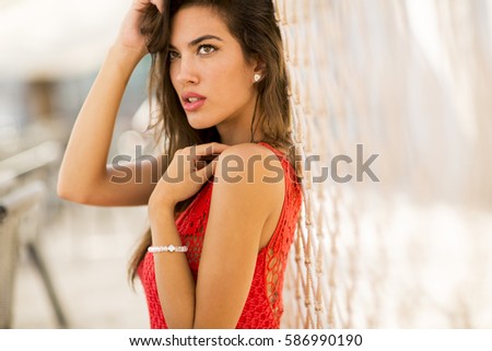 Young woman posing outside at summer in a red dress