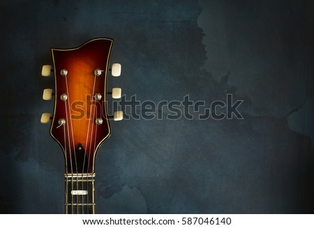 Close-up of headstock old electric jazz guitar on a dark blue background with copy space Royalty-Free Stock Photo #587046140