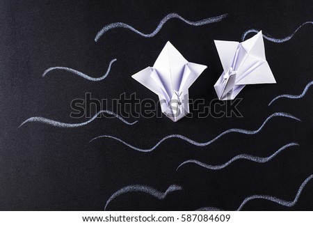 Pair of swans, origami on a dark background
