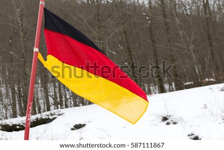 German flag planted in the snow in a mountain resort