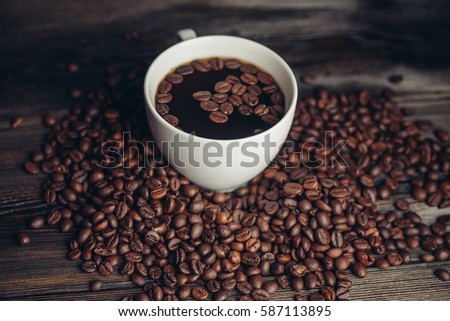coffee beans, black background, cup, saucer.