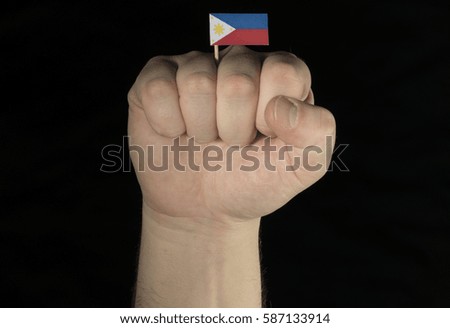 Man hand fist with Philippine flag isolated on black background