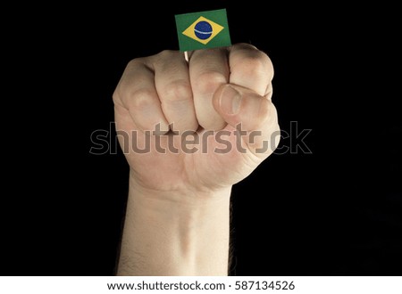 Man hand fist with Brazilian flag isolated on black background