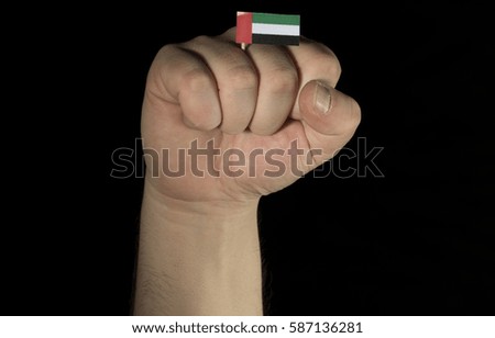Man hand fist with United Arab Emirates flag isolated on black background
