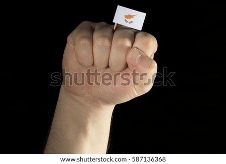 Man hand fist with Cypriot flag isolated on black background