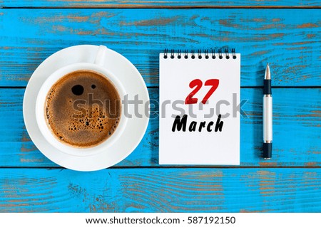 March 27th. Day 27 of month, loose-leaf calendar on blue wooden table background with morning coffee cup. Spring time, Top view. World Theatre Days