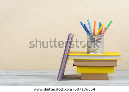 Book stacking. Open book, hardback books on wooden table and blue background. Back to school. Copy space for text.