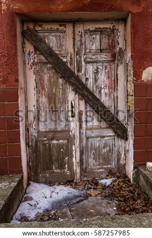 Old retro vintage exterior door in old building. Front door of traditional European design obsolete. Vintage view of an old window, door scratched textured surface. Old-fashioned carved ornaments